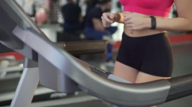 Düz mide ve ince kalça aktif genç kadının spor salonunda treadmill yürüyüş