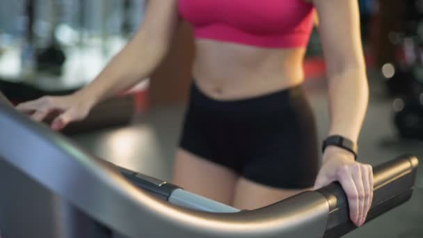 Mujer delgada deportiva caminando y corriendo en la cinta de correr, ejercicio activo en el gimnasio — Vídeo de stock