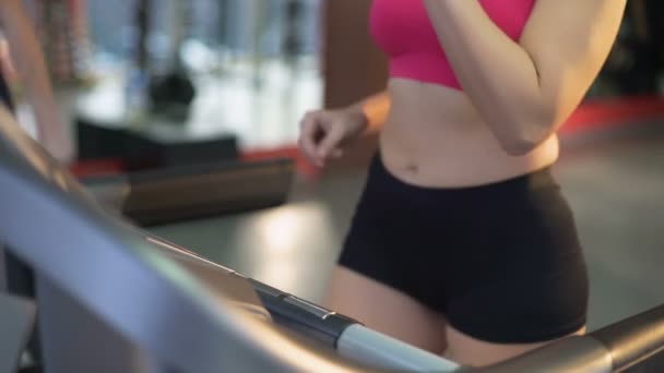 Υγιείς ταιριάζουν lady άσκηση στο διάδρομο και το πόσιμο νερό για αναψυκτικό — Αρχείο Βίντεο