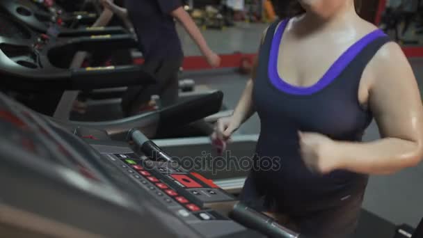 Mujer con exceso de peso corriendo rápido en la cinta, trabajando duro para el cuerpo delgado — Vídeo de stock