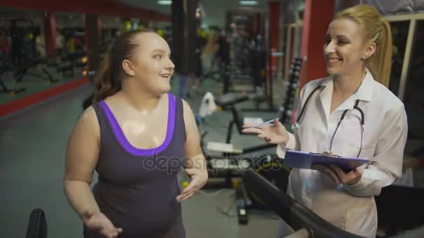 激动的女人，在健身房训练，说话营养学家，出于结果 — 图库视频影像