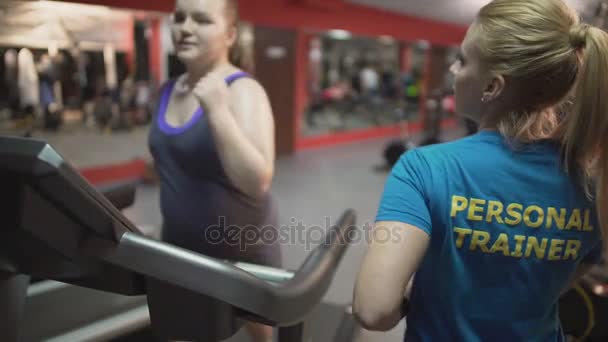 Personal fitness trainer motivating overweight girl during workout, high five — Stock Video