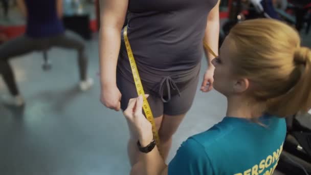 Personal fitness trainer measuring overweight woman waist, satisfied with result — Stock Video