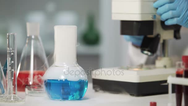 Биохимический эксперимент, жидкое вещество испаряется во фляжке Эрленмейера — стоковое видео