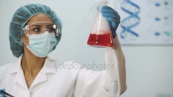 Biyokimyasal araştırma, kimyasal tepkime kabı içinde tıbbi bilim adamı — Stok video