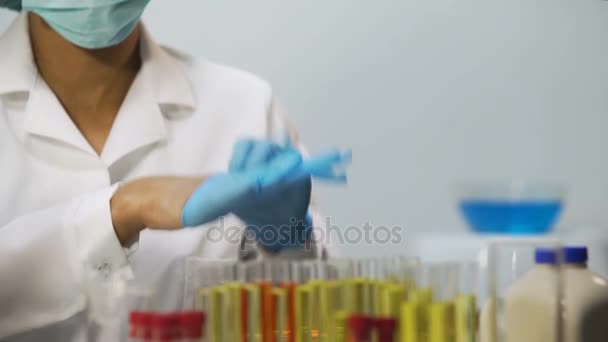 Mujer poniéndose guantes de látex en el laboratorio, científica preparándose para la investigación — Vídeos de Stock