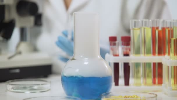 Pallone chimico fumante in piedi sul tavolo in laboratorio, esperimento chimico — Video Stock