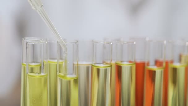 Investigación bioquímica, científico arrojando suero en tubos de vidrio, cosmetología — Vídeo de stock