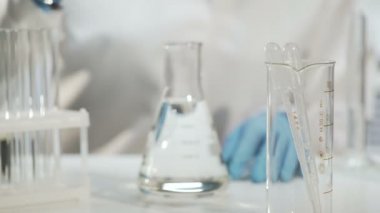 Kimyager sıvı, kimyasal deney ile konik şişesi içine madde ekleme
