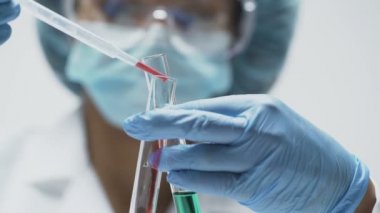 Biyolog test tüpleri için kırmızı sıvı damla ekleyerek deney biter