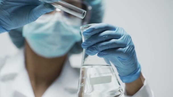 Chemiker beobachtet chemische Reaktion nach Zugabe von Testmaterial in konischen Kolben — Stockvideo