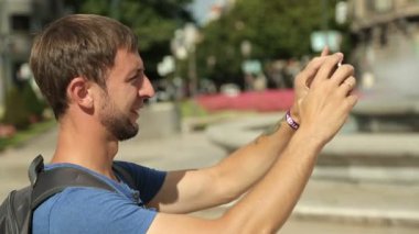 Genç adam alarak resim aracı, meraklı turist Simgesel Yapı fotoğraf çekimi