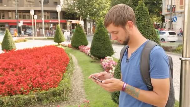 Active male urban resident checking mobile app on smartphone, big city lifestyle — Stock Video