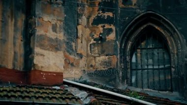 Eski duvar eski püskü çatı ile Gotik binanın terk ve kirli pencere çubuklu