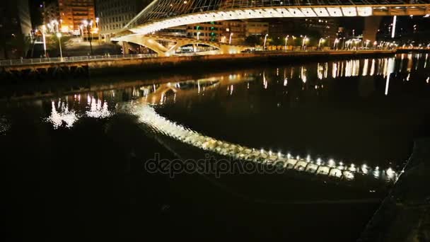 Puente de Zubizuri a través del río Nervión iluminado por la noche, viaje a Bilbao — Vídeo de stock