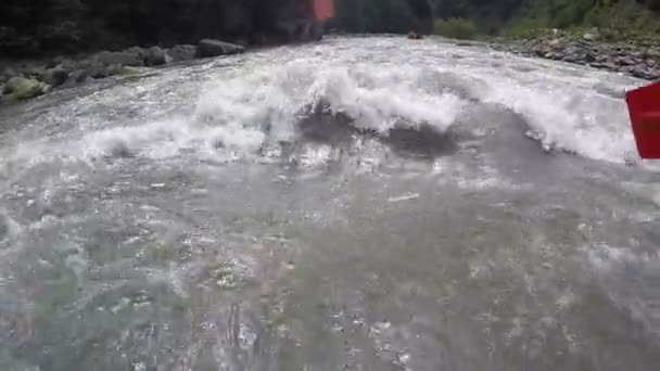 Atleta remando en barco de rafting, tratando de soportar las olas desastrosas del río — Vídeo de stock