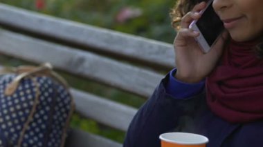 Sıcak çay tutarak ve konuşma açık havada, telefonda konuşurken çok ırklı kadın