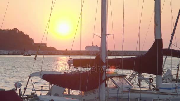 Beautiful sunset view from seaside city, boats at dock, cruise ship on horizon — Stock Video