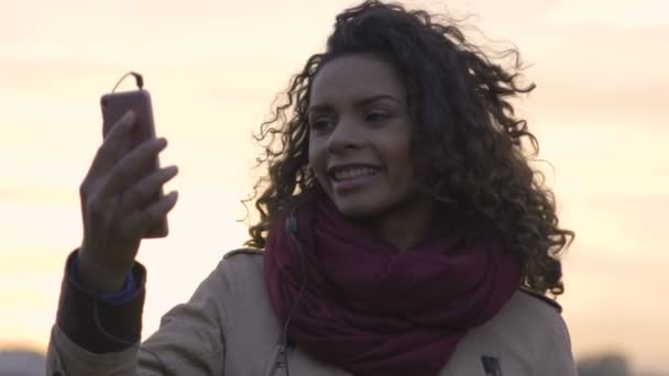 Joven hermosa mujer viendo música favorita clip en el teléfono inteligente, bailando — Vídeos de Stock