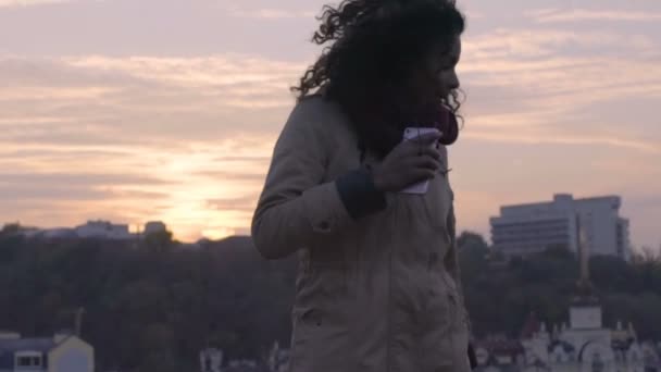 Jovencita bailando y divirtiéndose al atardecer, disfrutando de la música al aire libre, felicidad — Vídeos de Stock