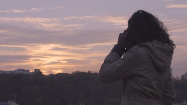 日没、自由に携帯電話の会話を終えた若い自信を持って女性 — ストック動画