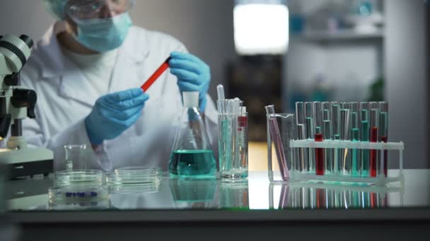 Asistente de laboratorio examinando muestras de sangre médica buscando sedimentos — Vídeo de stock