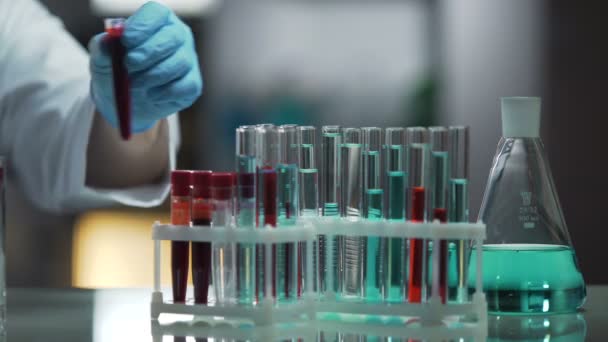Superficie de trabajo de laboratorio ocupada por tubos de ensayo y frascos, proceso de investigación — Vídeos de Stock