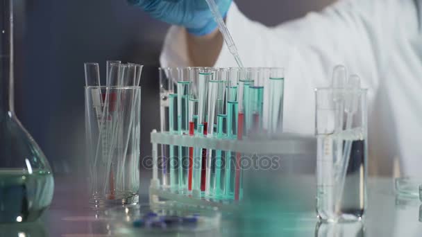 Laboratório cientista realizando testes adicionando gota de reagente à mistura — Vídeo de Stock