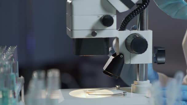 Analista de pesquisa ajustando microscópio para detectar glóbulos vermelhos e brancos — Vídeo de Stock