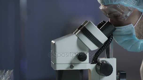 Neurosurgeon carrying out surgery on brain, looking in microscope, microsurgery — Stock Video