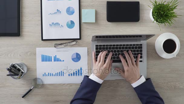 Business person working on laptop and drinking coffee in office, top-view — Stock Video