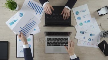 Şirket istatistikleri, tartışırken dizüstü bilgisayarlarda çalışan meslektaşlarının eller görünüm top