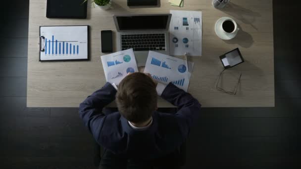 Sad businessman sitting at table and thinking about debts, bankruptcy, top view — Stock Video