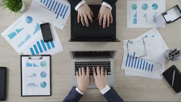 Hands of businessmen typing on laptops opposite each other, funny top view — Stock Video