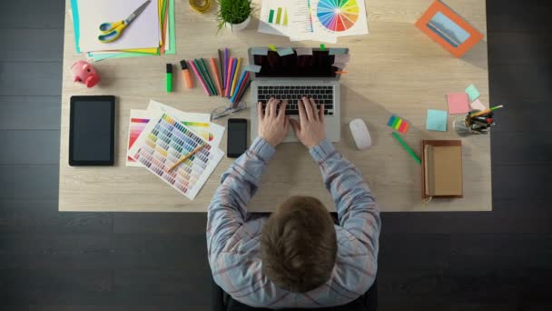 Creatieve man typen op laptop, stapel geld stijgt op tafel, succesvol opstarten — Stockvideo