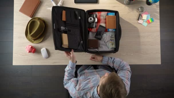 Ο άνθρωπος που συσκευάζονται αποσκευές του, λαμβάνοντας καπέλο και πρόκειται να συναντήσετε νέες περιπέτειες, τουρισμός — Αρχείο Βίντεο