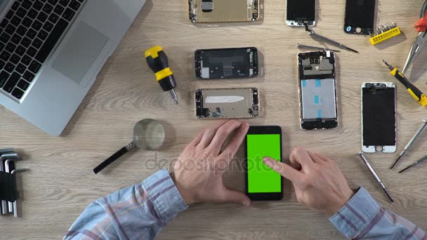 Reparador comprobar la funcionalidad del teléfono después de la fijación, smartphone con pantalla verde — Vídeo de stock