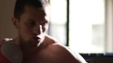 Şiddetle kum torbası, yüz, duygular saldıran güçlü erkek boxer uyuşuk