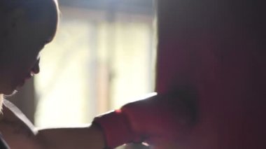Kadın atlet spor salonunda boks, boks torbası saldıran, rekabet için hazırlanıyor