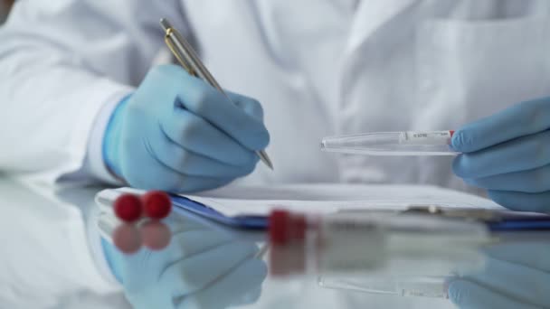 Zdravotní sestra vkládání výsledků testů pro virus protilátky krev do karet, epidemie — Stock video