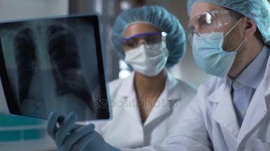 X-ışını akciğer laboratuarında okuyan, analiz ve tanı tartışırken doktorlar
