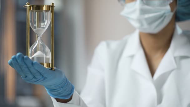 Medical worker holding sand hourglass on palm, terminal disease, life expiring — Stock Video