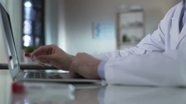 Doctor typing information from test tube, adding results to medical record, lab — Stock Video