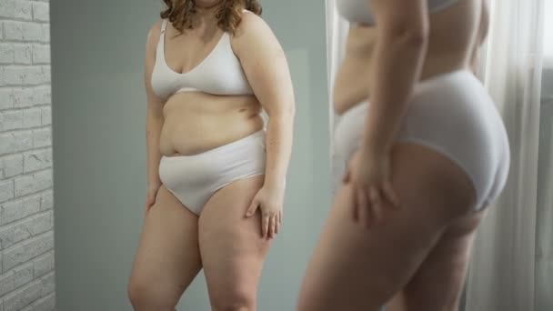 Sad girl embarrassed about her cellulite body and excess weight, health problem — Stock Video