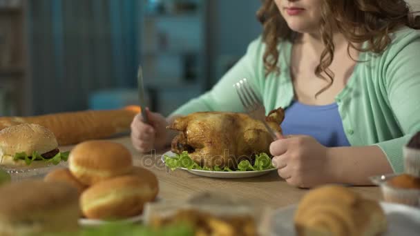 Faca afiadora feminina contra garfo sobre frango assado, preparando-se para comê-lo — Vídeo de Stock