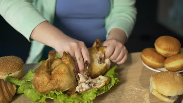 Mujer hambrienta con peso extra comiendo pollo asado graso, comida chatarra poco saludable — Vídeos de Stock