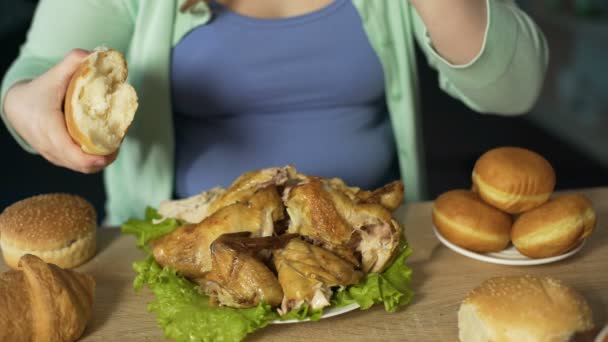 Obese female eating chicken and bread, unhealthy nutrition, overeating problem — Stock Video