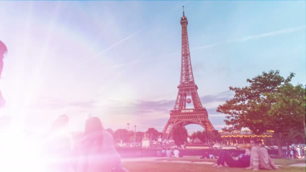 Paris, Frankreich - ca. Juni 2016: Sightseeing in der Stadt. Menschen sitzen auf dem Rasen und genießen den Blick auf den Eiffelturm in Paris in der Dämmerung — Stockvideo