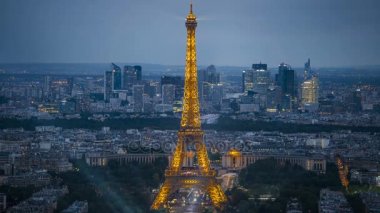 Şehir ışıkları Paris, ışıklı Eyfel Kulesi ve gökdelenler, alacakaranlıkta gecesine