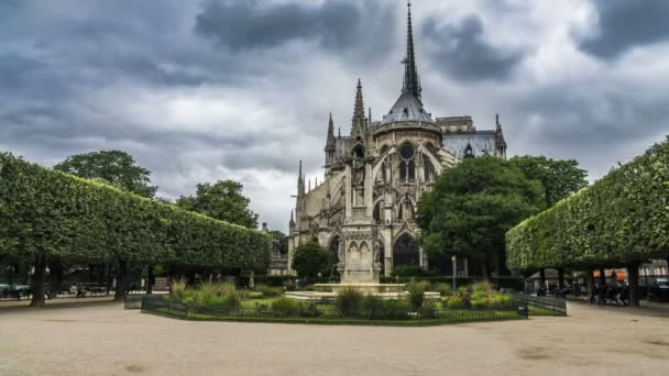 Gyönyörű kertben, közel a Notre-Dame de Paris Cathedral, vastag, szürke felhők az égen — Stock videók